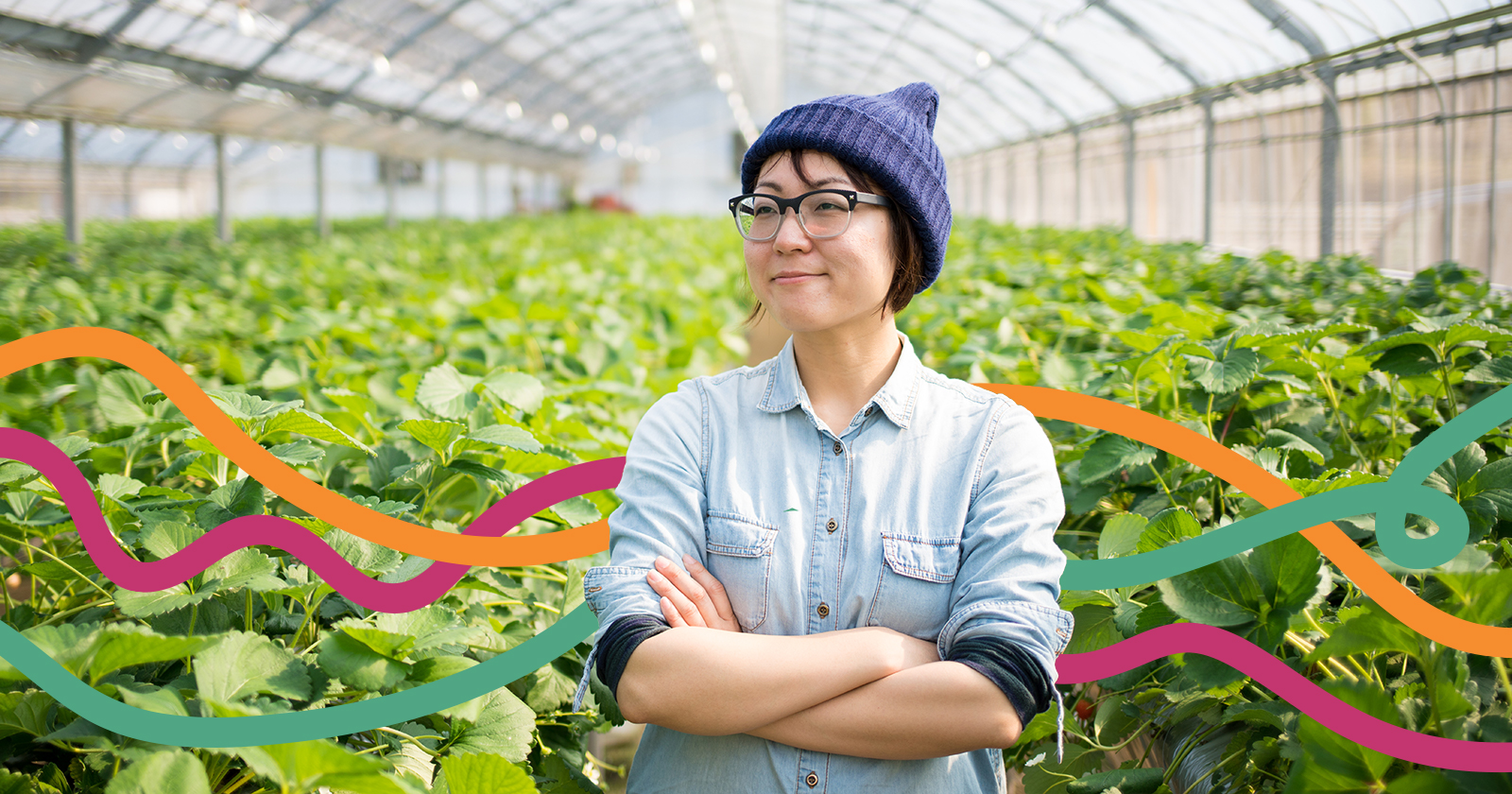 Smiling person standing in a greenhouse with colorful lines behind them.